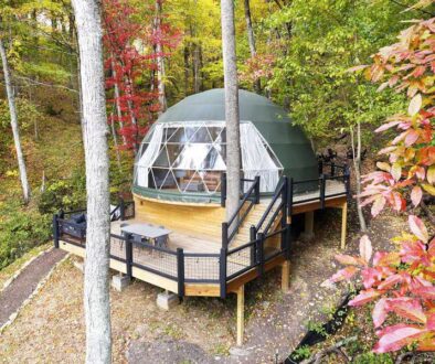 Geodesic domes are covered with canvas and have floor-to-ceiling windows across the front.