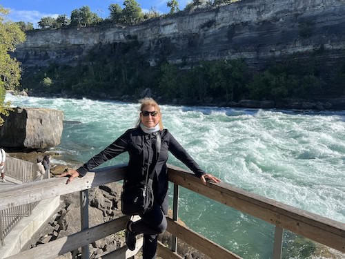 Sharon leaning on a railing by the Niagara River 