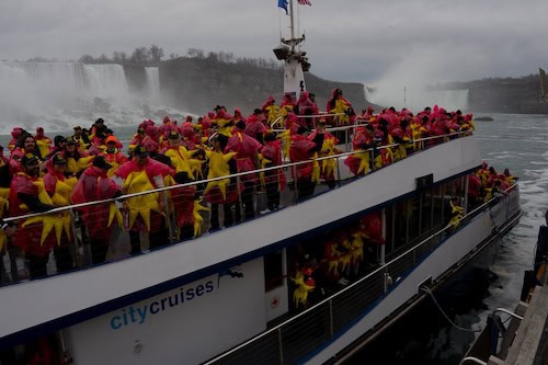a group of people on a boat in rain ponchos 
