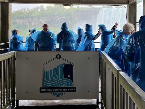 a group of people wearing blue raincoats at the upper level observation point at Journey Behind the Falls 
