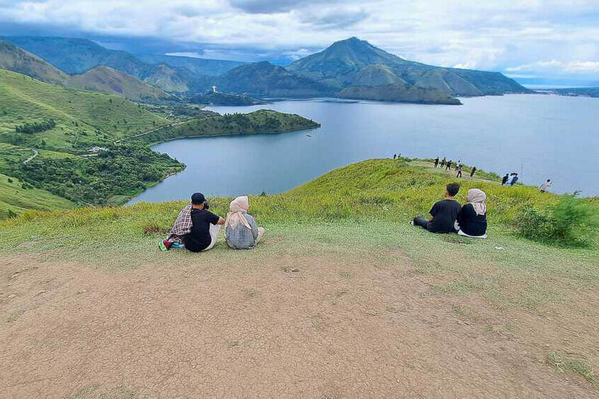How People Pay for Travel Today 1 People relax on the grassy hill overlooking the lake at Holbung Hill